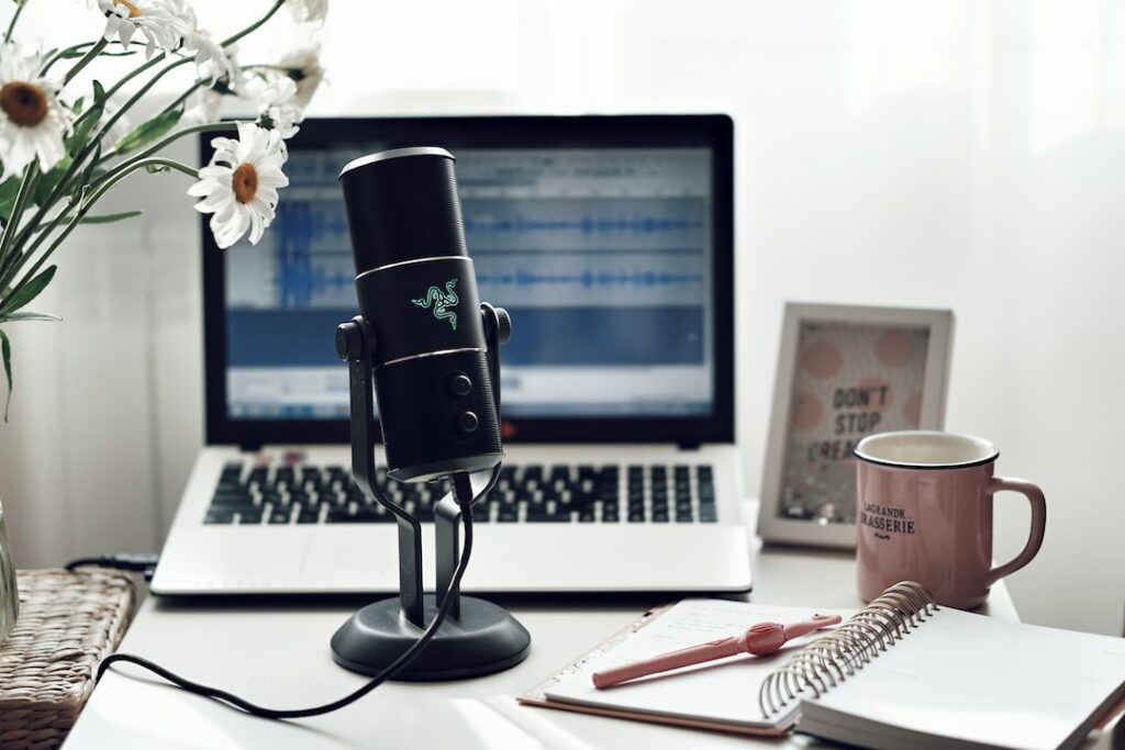 razer mic, laptop and notebook over a work desk
