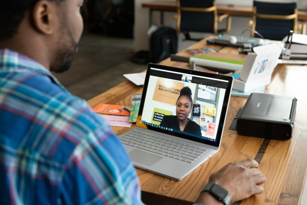 person talking with a women in video conference in laptop